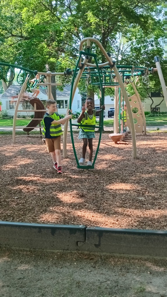 Two campers enjoy a neighborhood playground together
