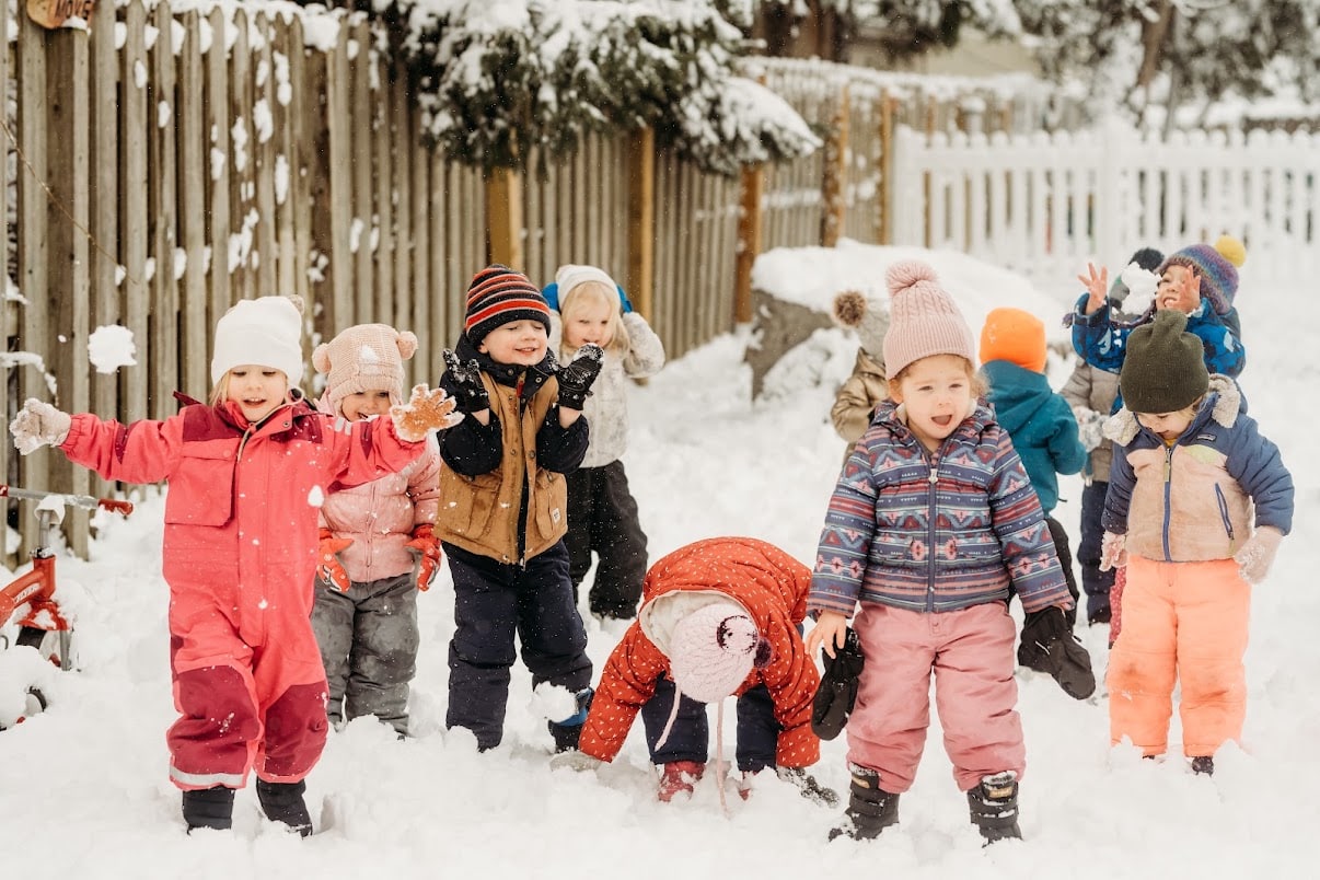 Children playing together in the snow at Huntington Woods